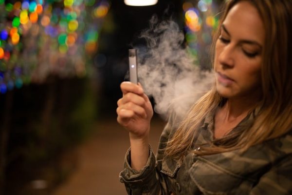 Femme fumant une cigarette électronique